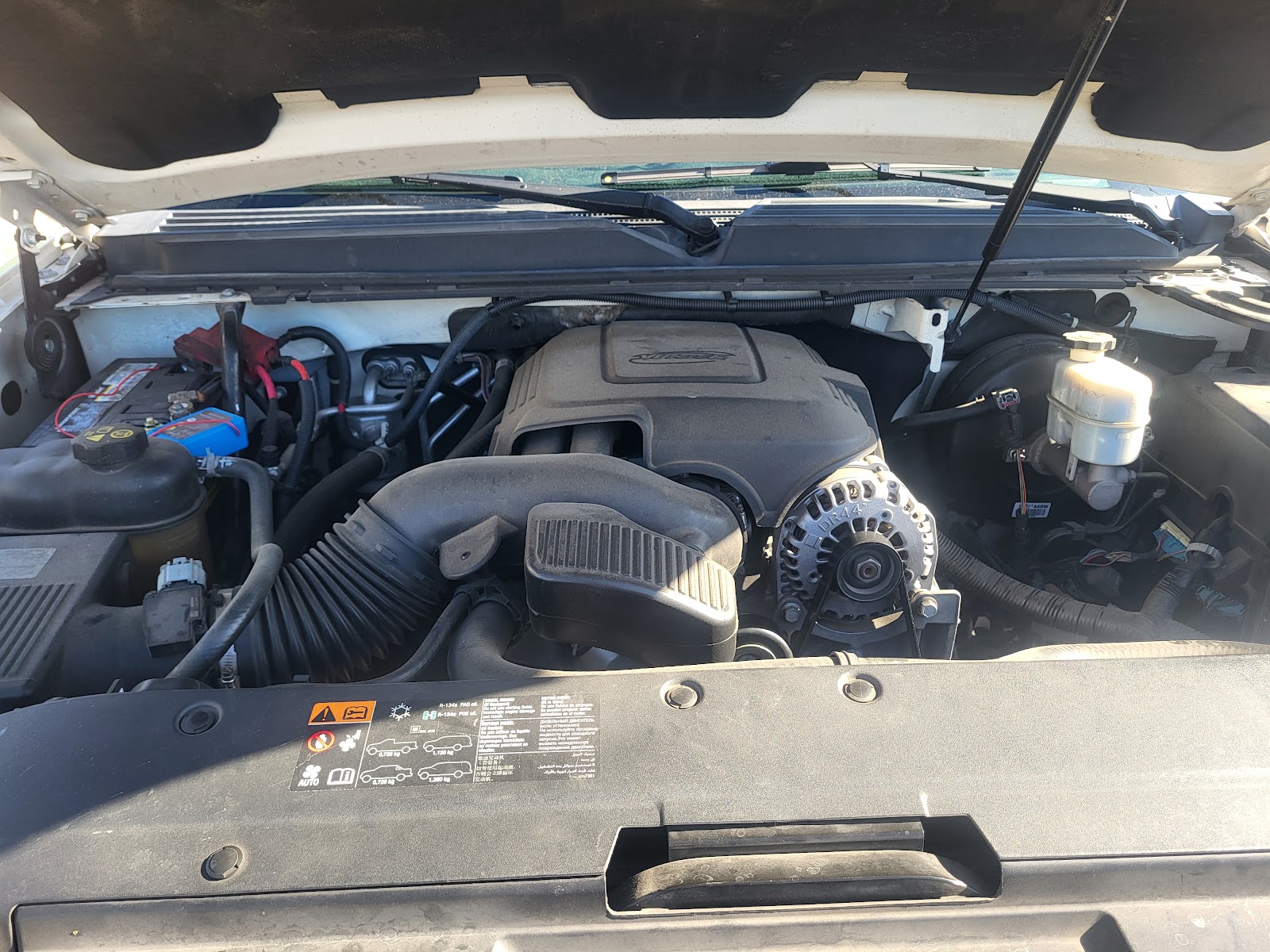 Open engine bay of a Chevrolet or GMC truck showing the engine and alternator
