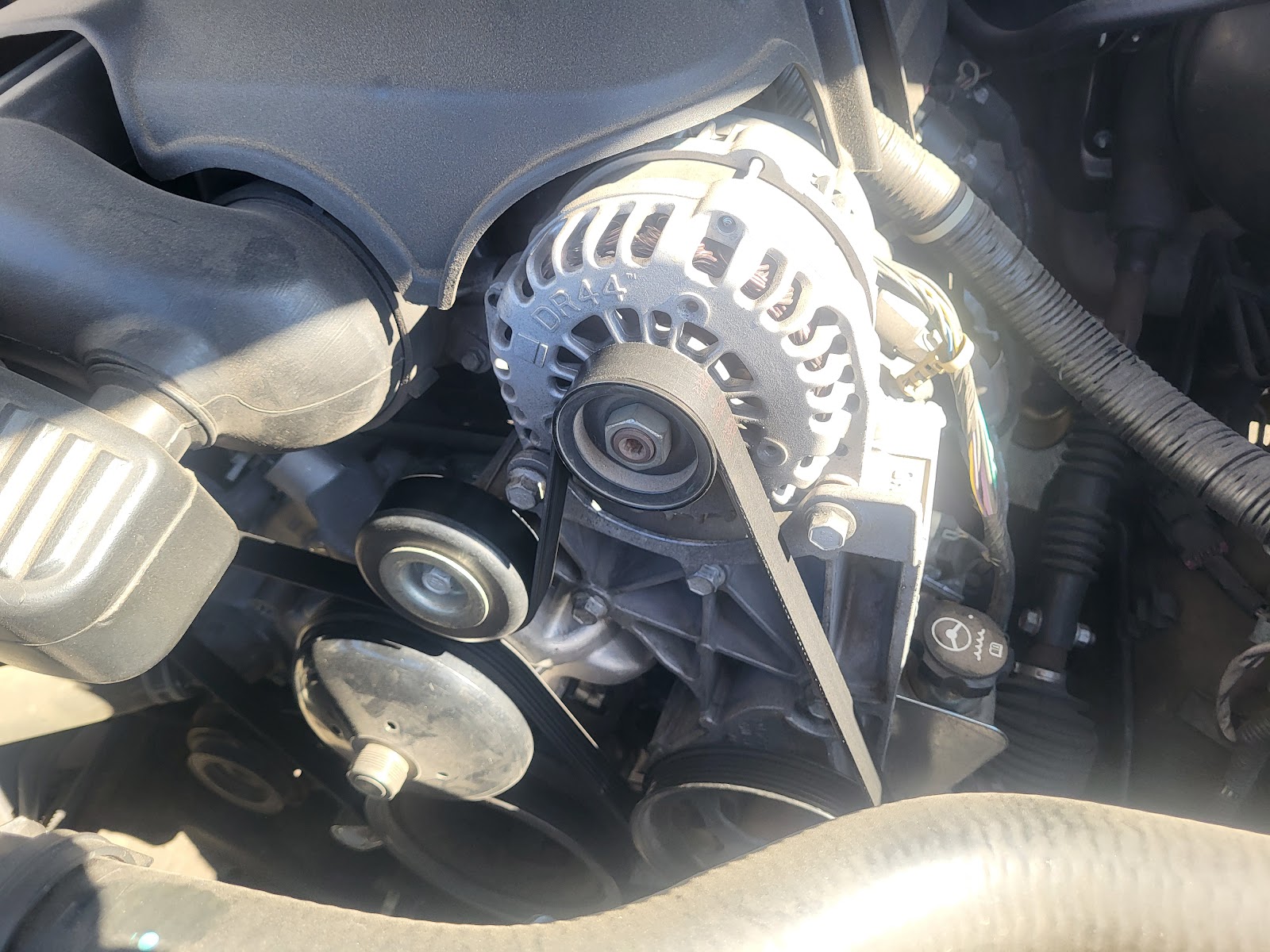 Close-up of a DR44 alternator and serpentine belt in an engine bay