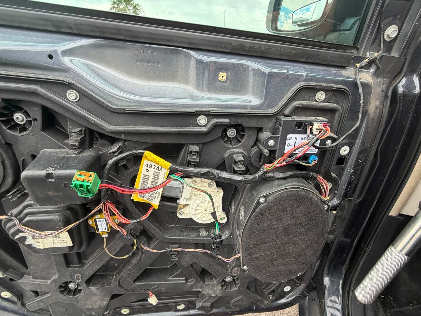 Interior of a car door panel removed showing the window motor and wiring harness